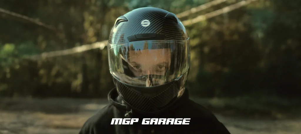 MGP Garage: Bartek Glin w kasku motocyklowym w leśnej scenerii, kadr z filmu reklamowego