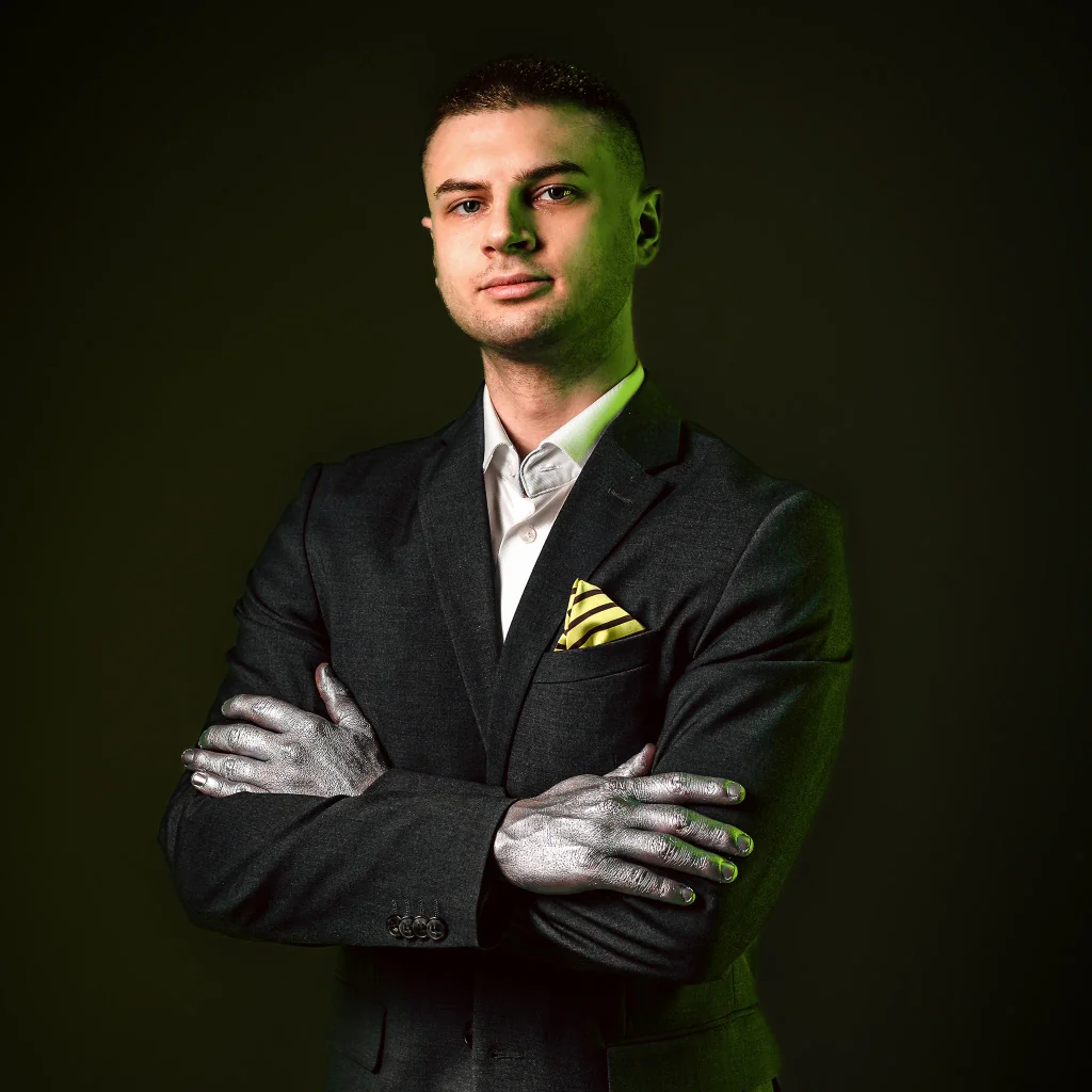 Oskar Makarski, CEO PIONA Studio, portret w garniturze na zielonym tle